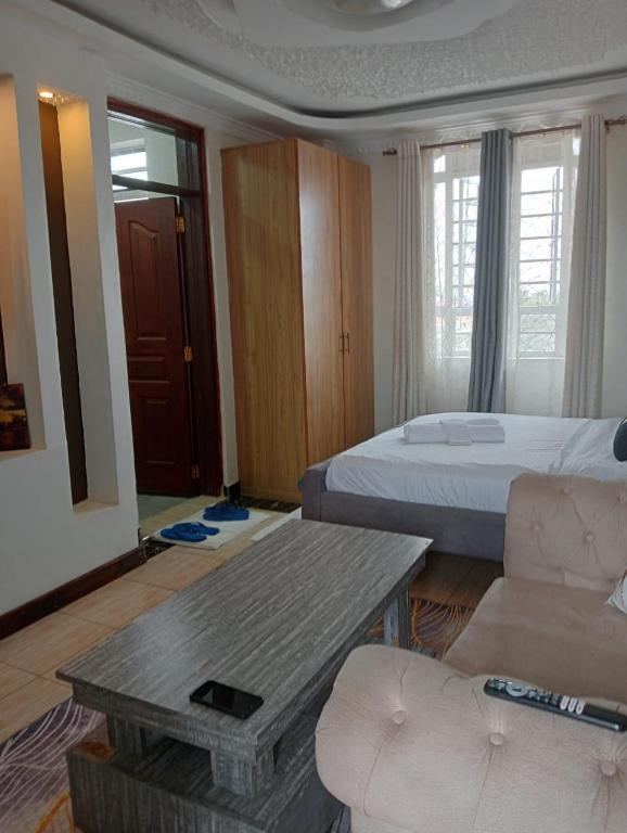 a hotel room with a bed and a couch and a table at SpringStone executive STUDIO apartment A19 in Ongata Rongai 