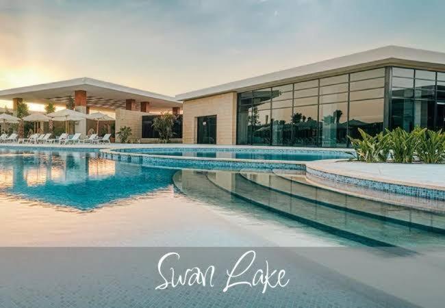 ein großes Schwimmbad vor einem Gebäude in der Unterkunft Swan lake magical chalet! North coast in Zāwiyat al ‘Awwāmah