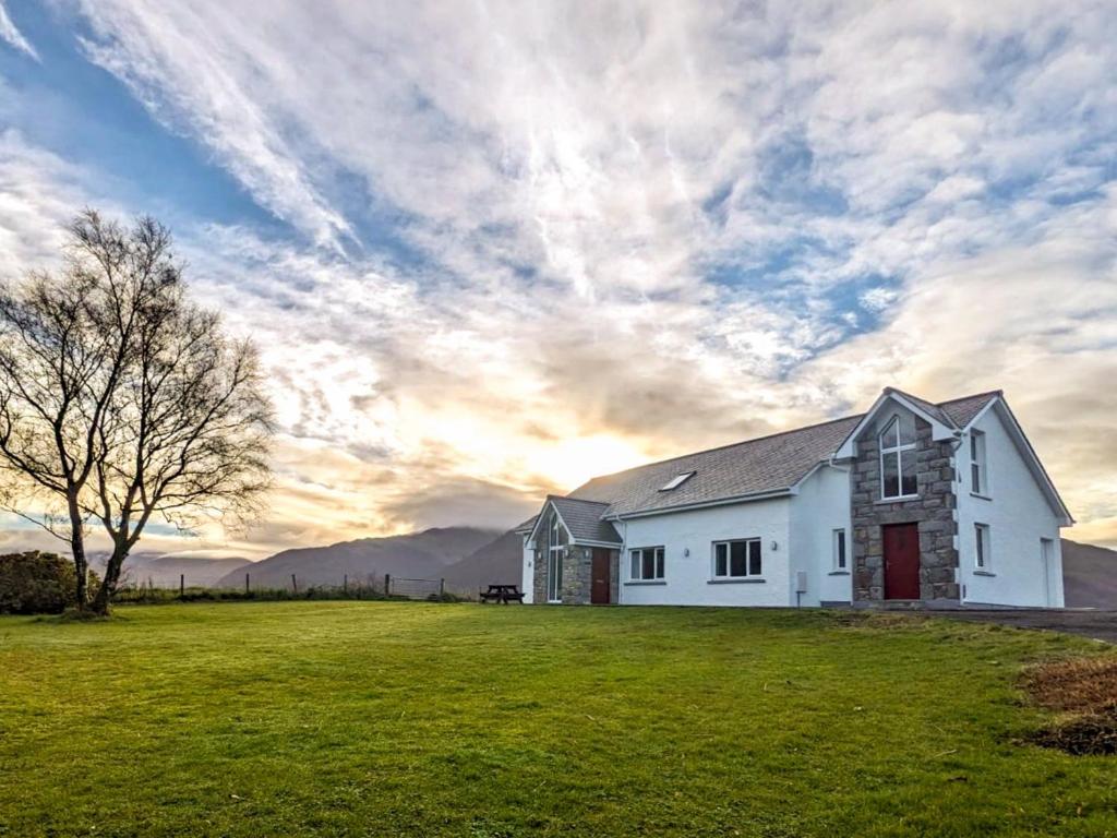 a white house with a tree in a field at 3 bed property in Onich CA159 in Onich