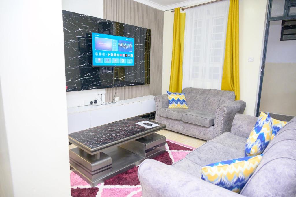 a living room with a couch and a tv at SpringStone executive apartment A10 in Ongata Rongai 