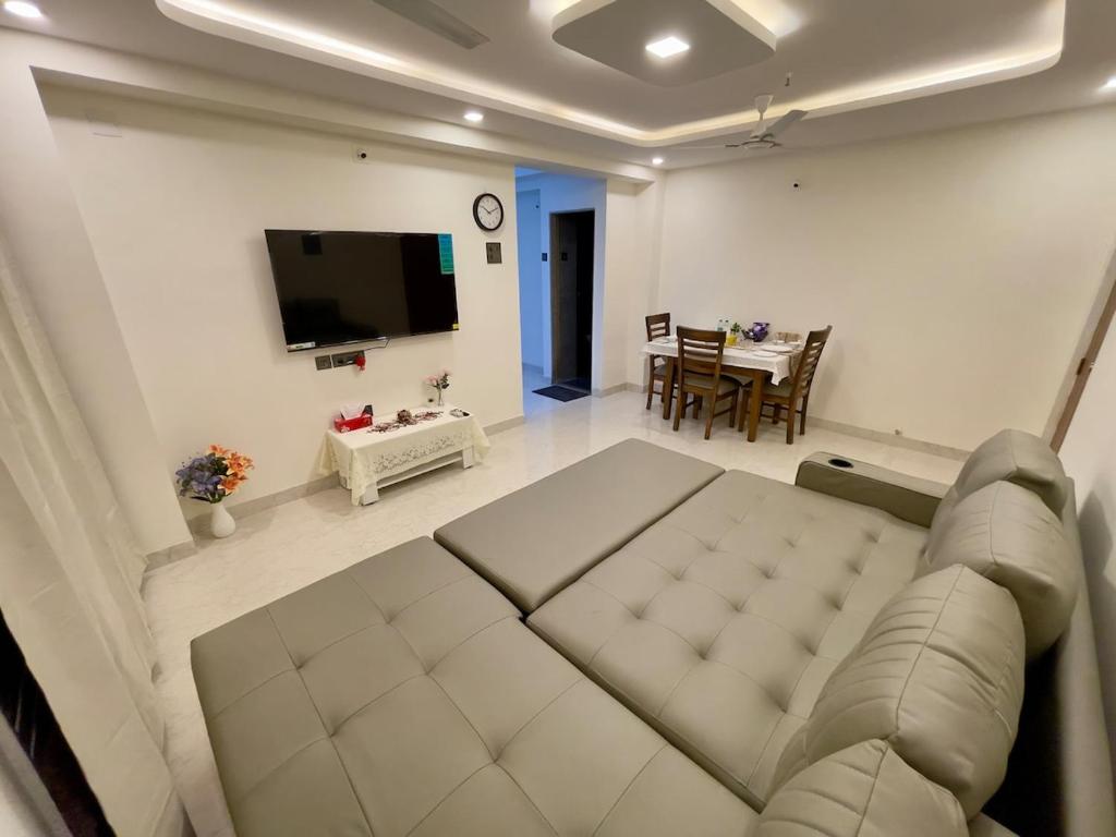 a living room with a couch and a television at Lake View 2 BHK in Powai A in Mumbai