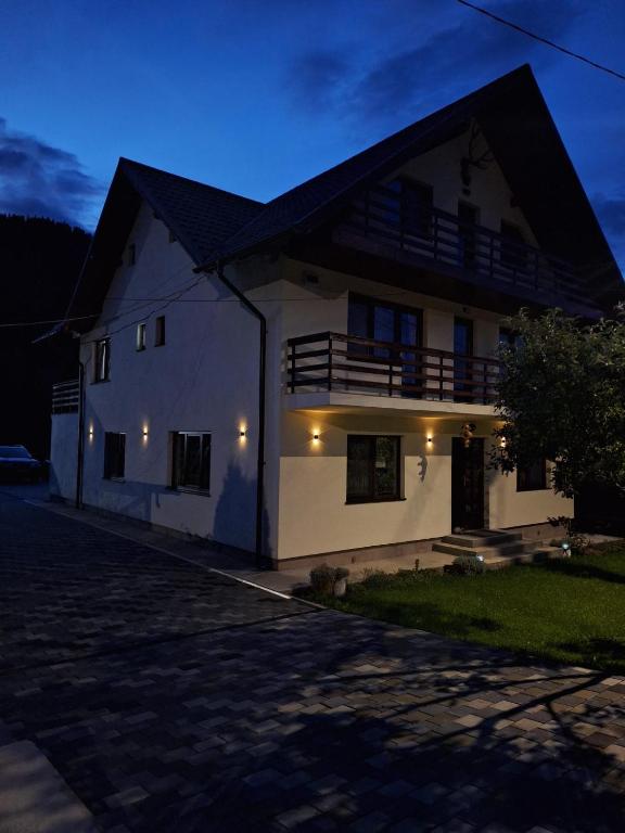a white house with a black roof at night at Casa Elena in Ceahlău