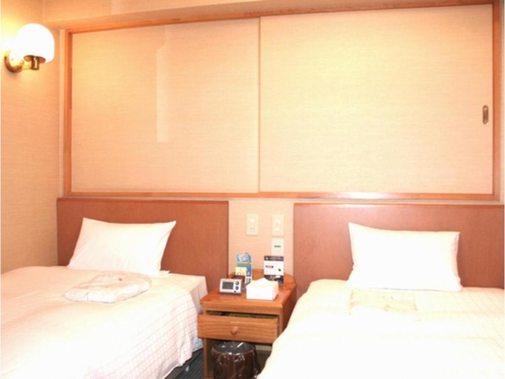 - une chambre avec 2 lits et une armoire au-dessus dans l'établissement Smile Hotel Hachinohe - Vacation STAY 56439v, à Hachinohe