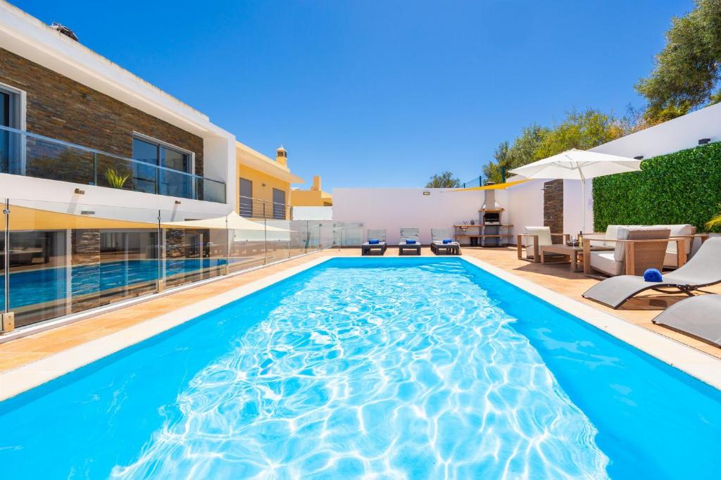 a swimming pool in the backyard of a house at Villa Clara do Sol in Estói