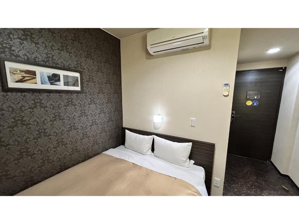 a small bedroom with a bed in a room at Smile Hotel Kokura - Vacation STAY 67776v in Kitakyushu