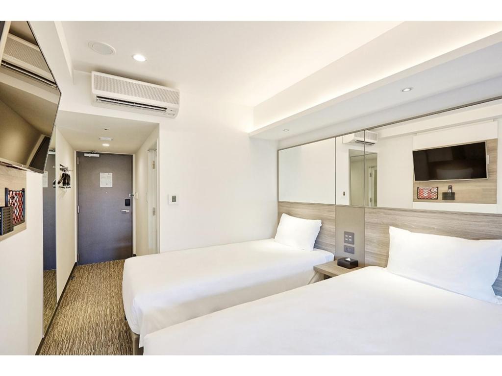 a hotel room with two beds and a tv at Smile Hotel Sapporo Susukino Minami - Vacation STAY 60224v in Sapporo