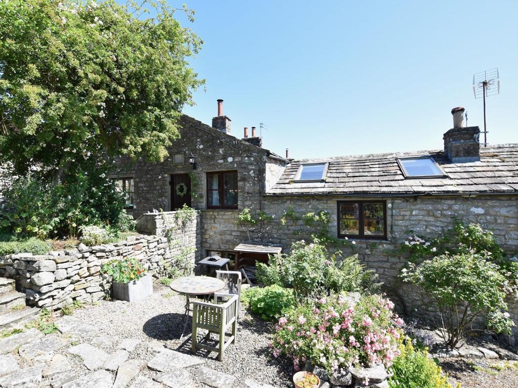 a stone house with a table and chairs in front of it at 1 Bed in Richmond 44401 in Reeth