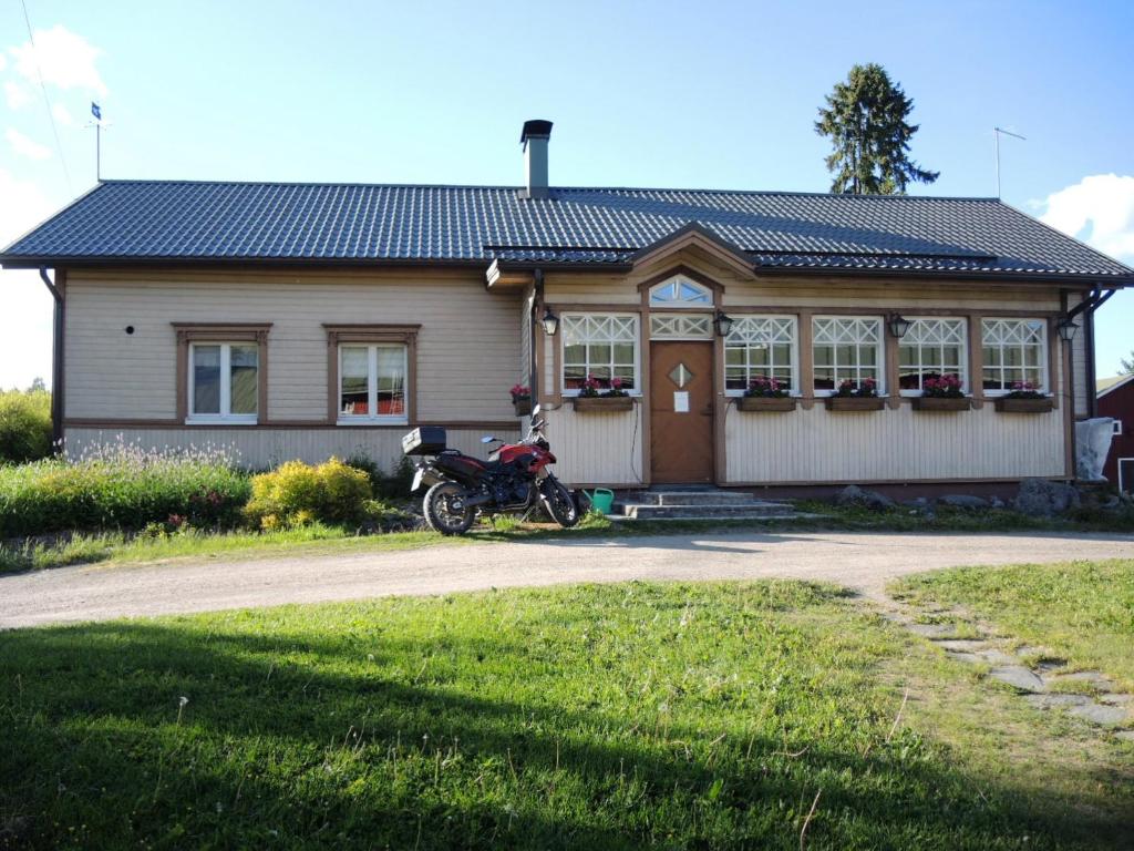 a motorcycle parked in front of a house at Tuukkalan Tila B&B in Ristiina