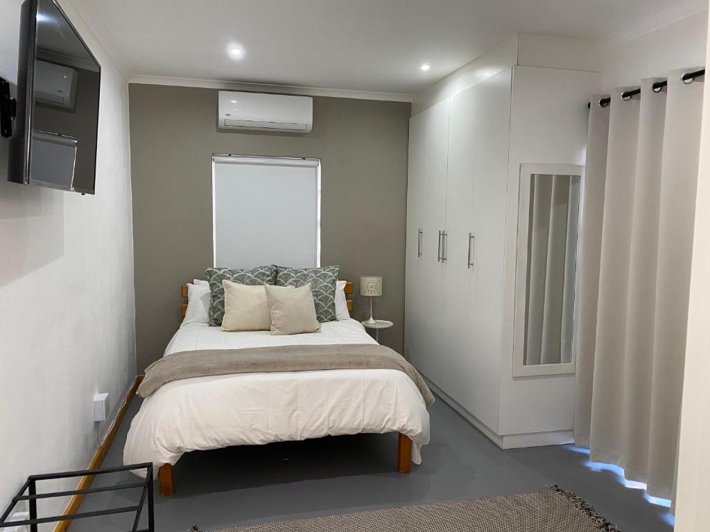 Un dormitorio con una cama y una ventana. en Ougat, en Douglas