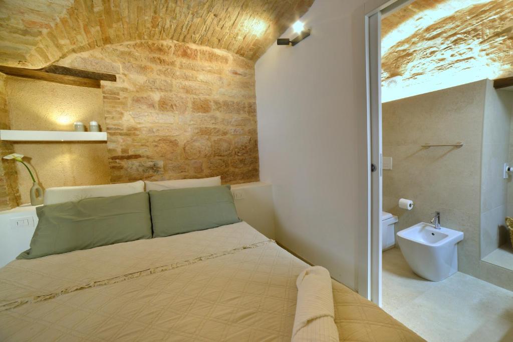 Un dormitorio con una cama grande y un baño. en Auditorium Rooms, en Foligno
