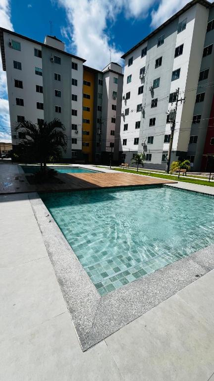a swimming pool in front of some buildings at Apto c TV Streaming Ar Wifi e Piscina in Ananindeua
