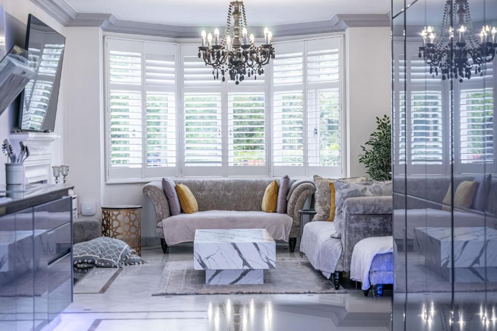a living room with a couch and a chandelier at Chingford Manor in Chingford