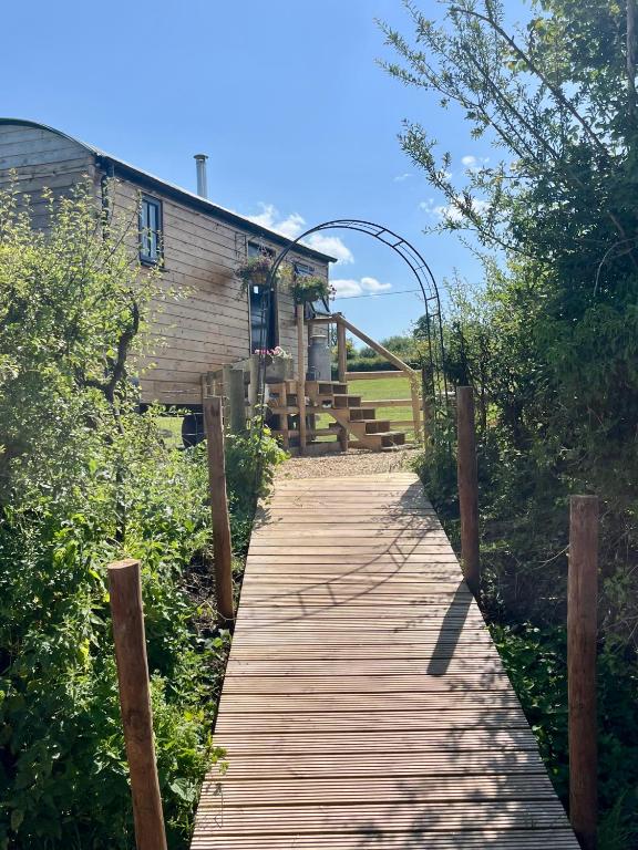 a wooden walkway leading up to a building at Wiltshire Weavers Hut in Chippenham