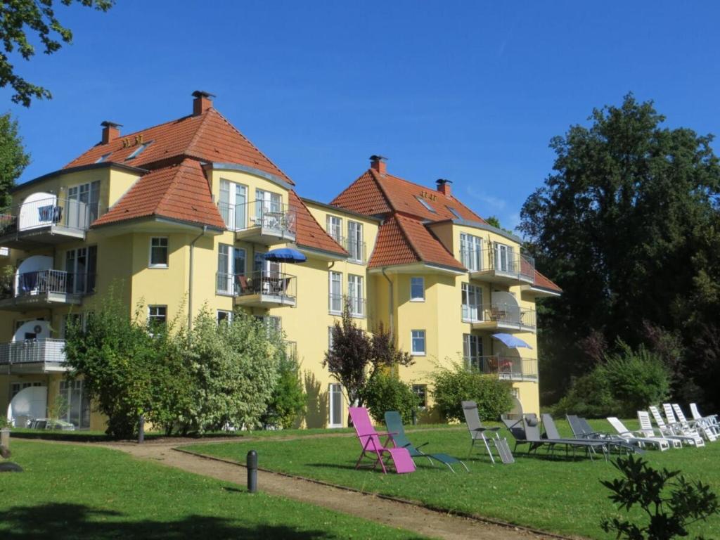 a large yellow building with chairs in front of it at Holiday apartment Seagull in Bad Saarow