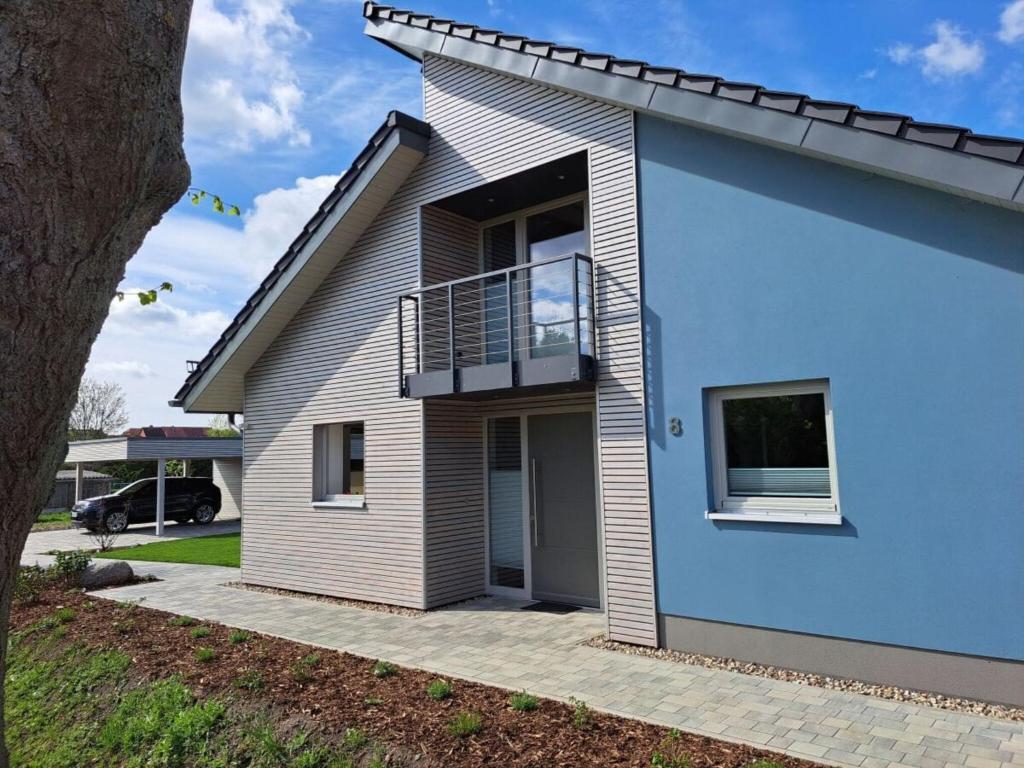 a blue and white house with a balcony at Holiday home Neukalen Comfortable holiday residence in Neukalen
