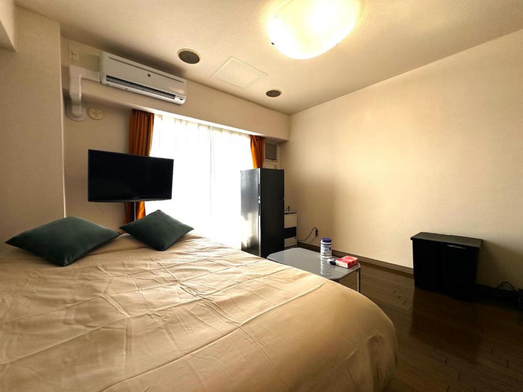 a bedroom with a bed with a television and a window at Tokan Nakanoshima Castel - Vacation STAY 19498 in Sapporo