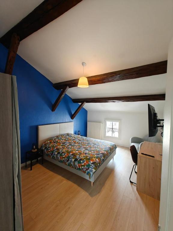 a bedroom with a bed and a blue wall at Hébergement 4 chambres indépendantes hyper-centre in Saint-Dizier