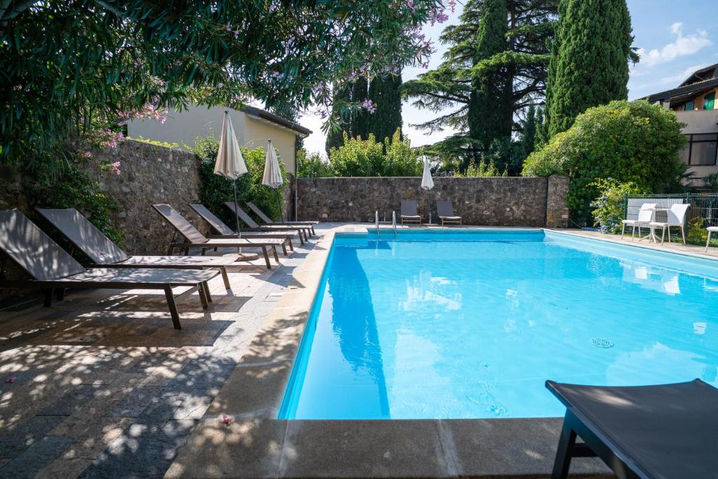 a swimming pool with chaise lounge chairs around it at Borgoluna Luxury Holiday House in San Felice del Benaco