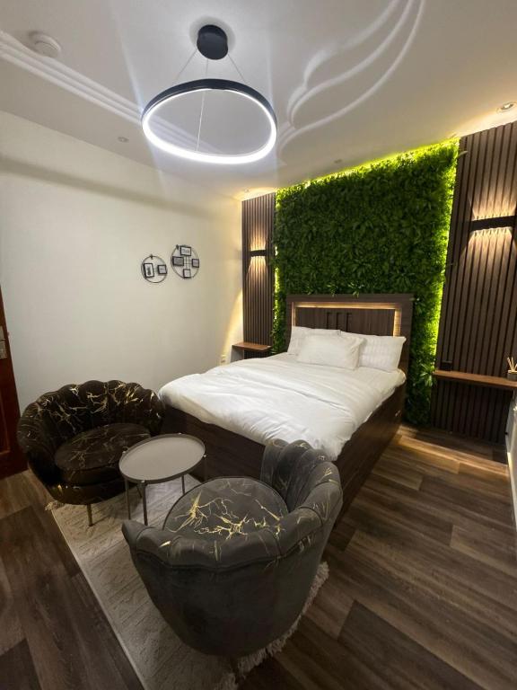 a bedroom with a bed with a green wall at شقق الريم in Medina