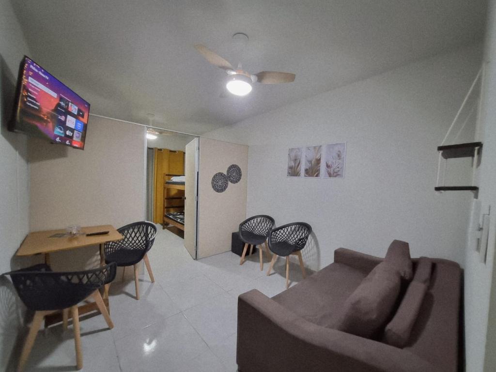 a living room with a couch and a table and chairs at Apartamento Praia Grande - Pé na Areia - Mirim in Praia Grande