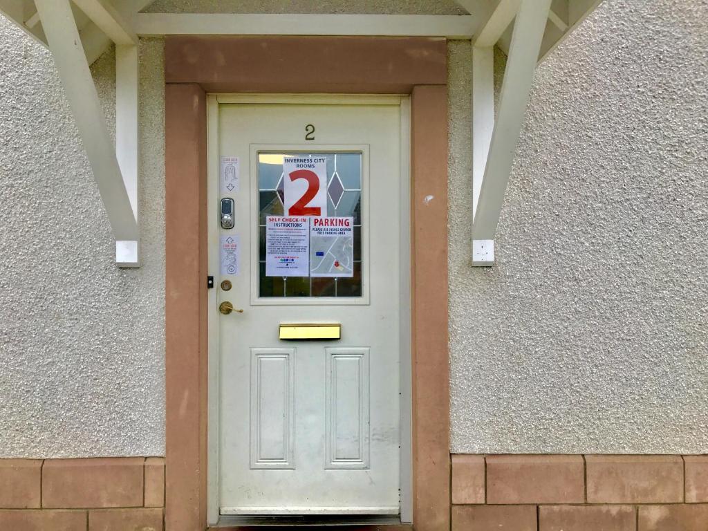 Eine weiße Tür mit Nummer zwei drauf. in der Unterkunft Woodgrove Holiday Homes in Inshes