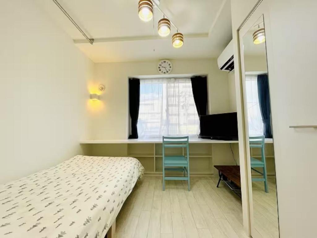 een slaapkamer met een bed, een bureau en een raam bij Cream Building - Vacation STAY 19747 in Sapporo