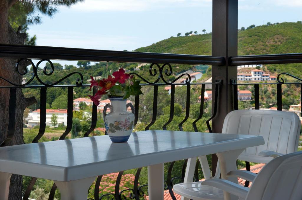 a vase with flowers sitting on a table on a balcony at Villa Anna Maria in Agia Paraskevi