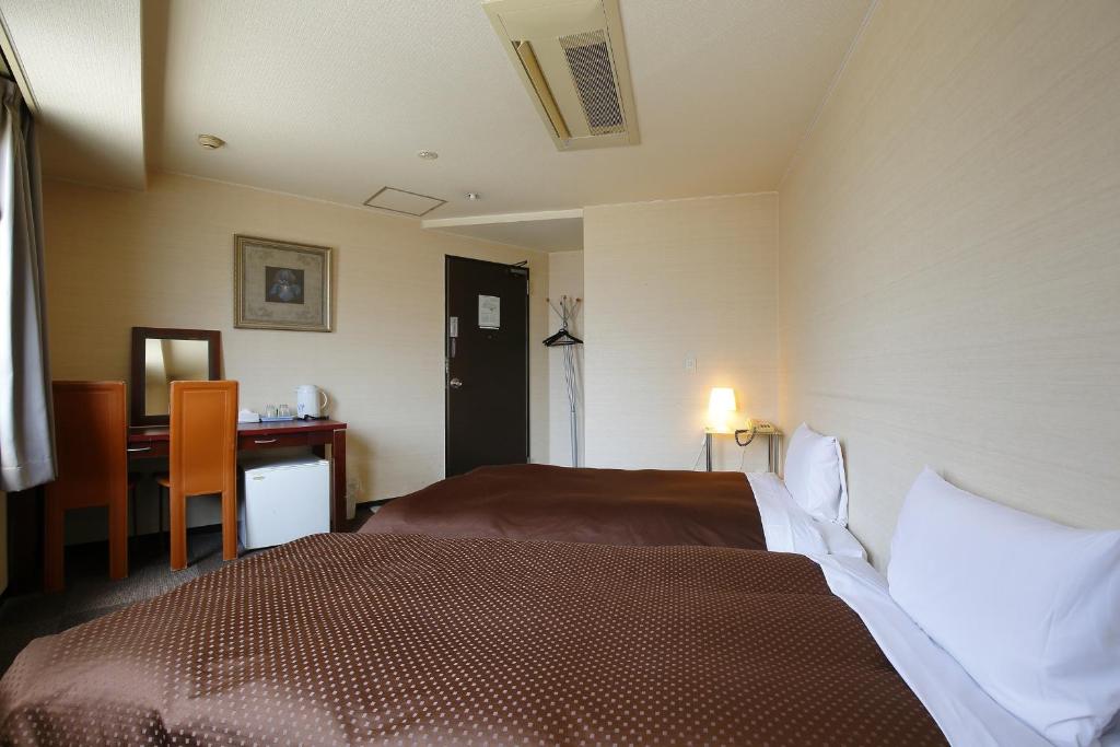 Postel nebo postele na pokoji v ubytování Grampus Inn Osaka Namba