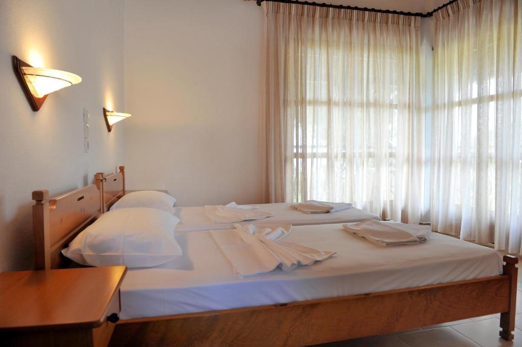 a bedroom with a bed with a desk and a window at Villa Anna Maria in Agia Paraskevi