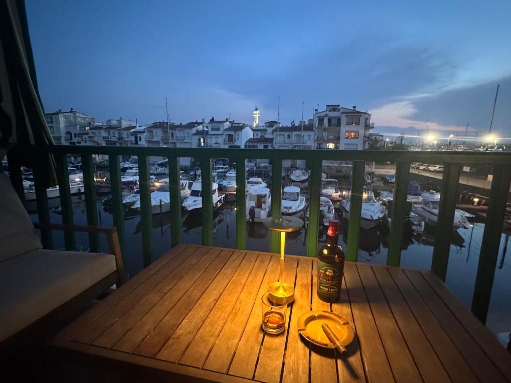 a table with two glasses and a bottle of wine on a balcony at Empuria sur les canaux in Empuriabrava