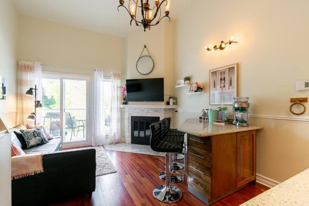 a living room with a desk and a fireplace at Charming Tremblant 1 Bedroom -Pool Hot Tub in Mont-Tremblant