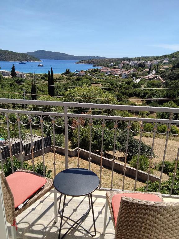 a balcony with chairs and a table and a view of the ocean at Apartman Ane in Slano
