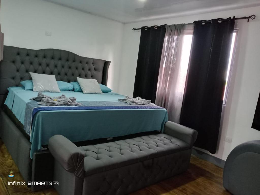 a bedroom with a bed and a couch and a window at Casa vistas de puerto mantica in Poneloya