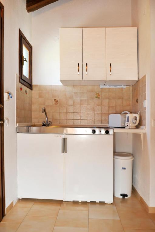 a kitchen with white cabinets and a sink at Villa Anna Maria in Agia Paraskevi