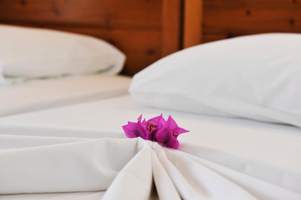 a purple flower sitting on top of a bed at Villa Anna Maria in Agia Paraskevi