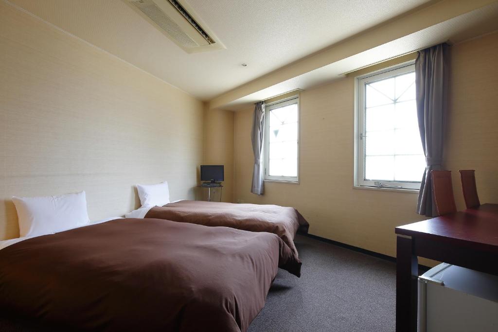 Postel nebo postele na pokoji v ubytování Grampus Inn Osaka Namba