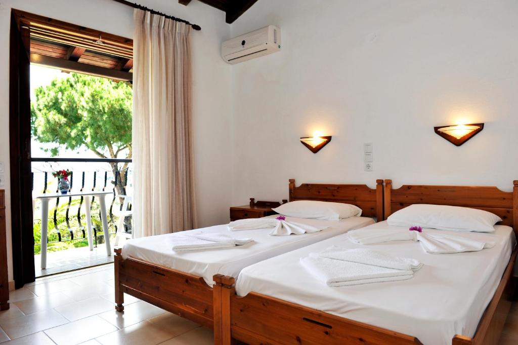 a bedroom with two beds and a large window at Villa Anna Maria in Agia Paraskevi