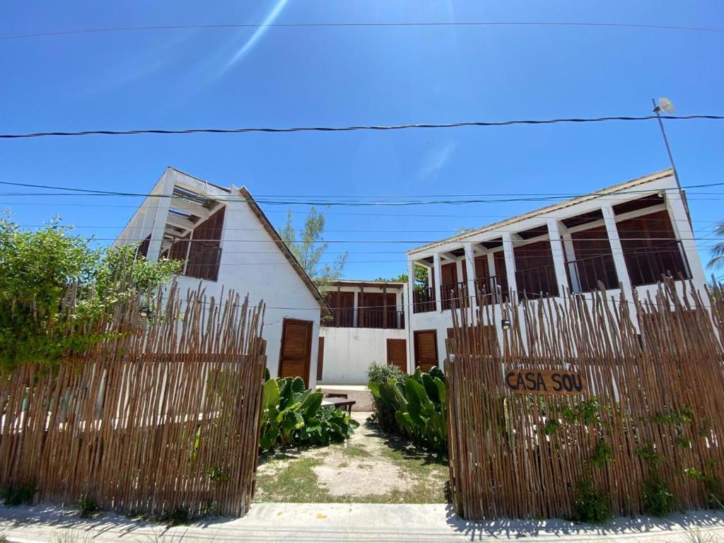 a fence in front of a white house at For Large group, UP TO 10 people Entire Space Rental 3 lodges with private pools in Holbox Island