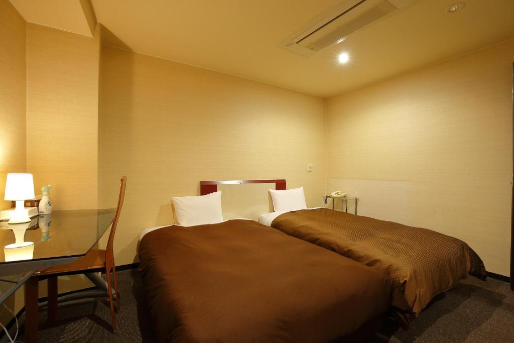 Postel nebo postele na pokoji v ubytování Grampus Inn Osaka Namba