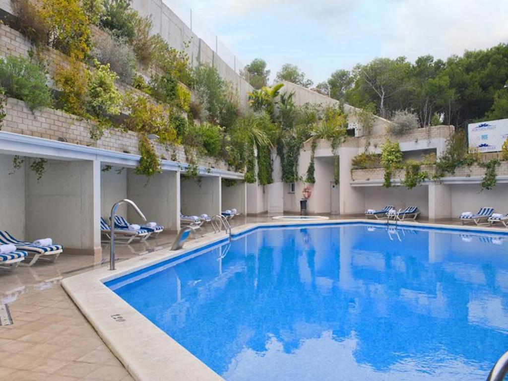 una gran piscina con sillas y un edificio en Dream Away Alicante, en Alicante
