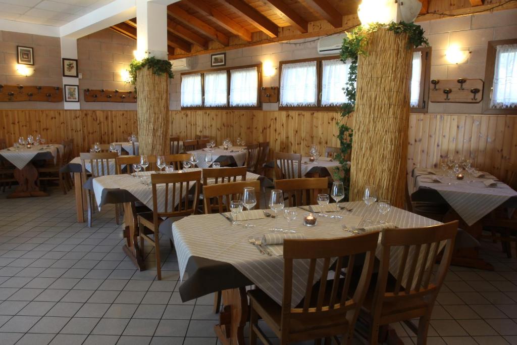 un restaurante con mesas y sillas en una habitación en Hotel Agriturismo Al Luogo Del Giulio, en Maniago