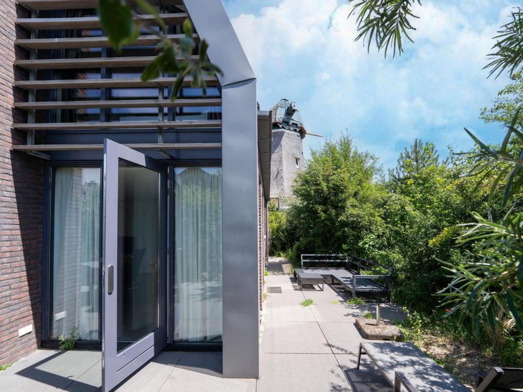 a glass door on a building next to a building at Villa in Egmond near Beach & Windmill in Egmond aan den Hoef
