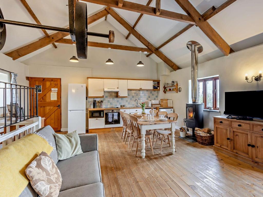 4 Bed in Morwenstow CORYS في Morwenstow: مطبخ وغرفة معيشة مع أريكة وطاولة