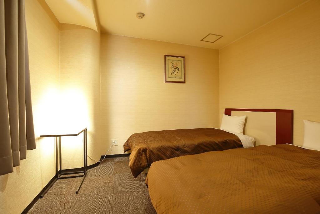 Postel nebo postele na pokoji v ubytování Grampus Inn Osaka Namba