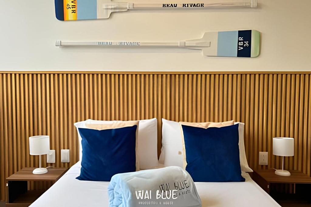 una stanza d'albergo con un letto con cuscini blu di Wai Blue/Salguero Suites/Autentico/Cerca MAR/SSC21 a Gaira