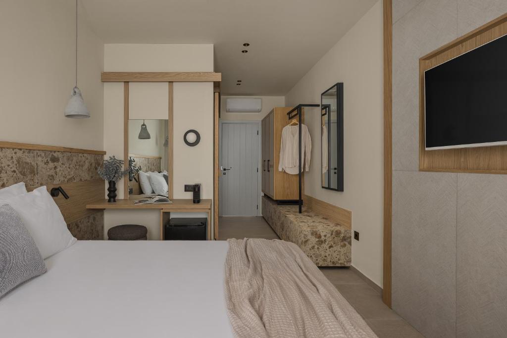 Un dormitorio con una cama, un escritorio y un televisor. en Lumora Suites, en Kavos