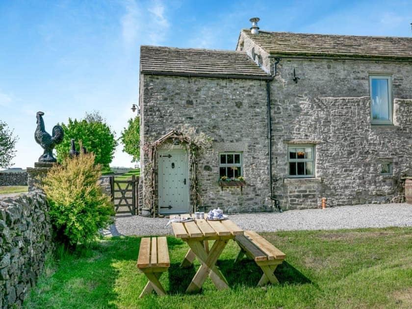 een picknicktafel voor een stenen gebouw bij Sweet knoll cottage in Buxton