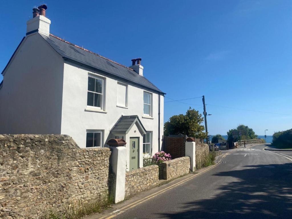a white house on the side of a road at 3 Bed in Charmouth 93420 in Charmouth