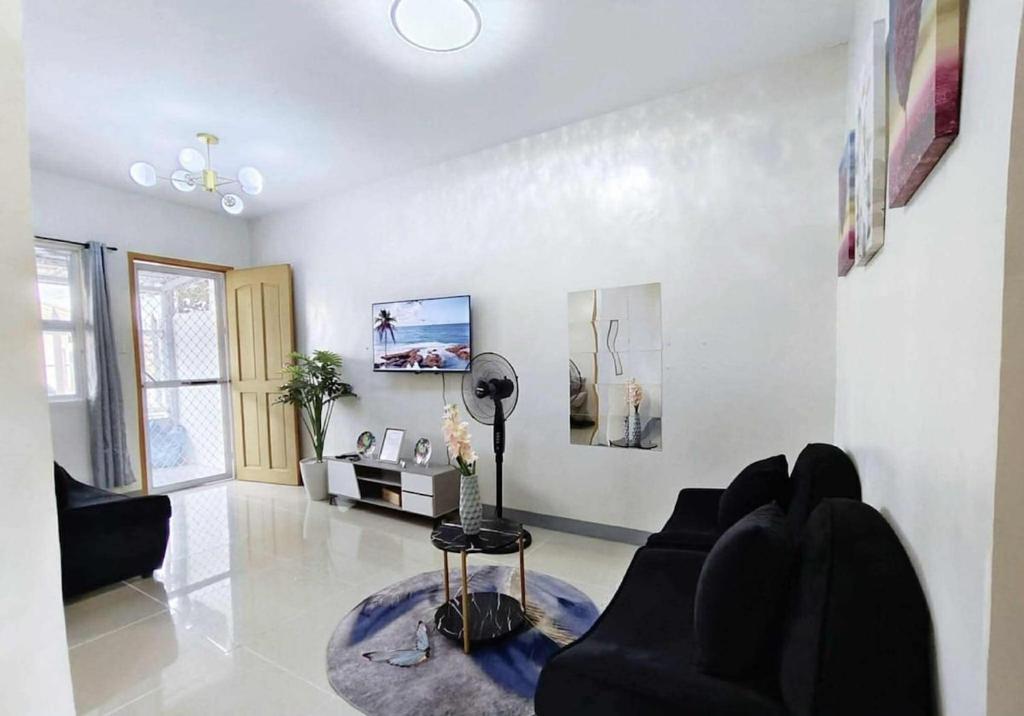uma sala de estar com um sofá e uma mesa em Wonderfully cozy apartment em Tagum