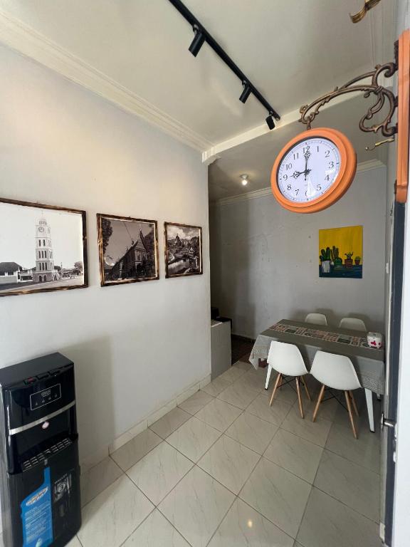 a room with a table and a clock on the wall at D' Mande Homestay Bukittinggi in Bukittinggi